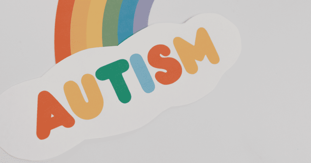 A rainbow leading to a cloud that has the word "Autism" written on it with colored letters.