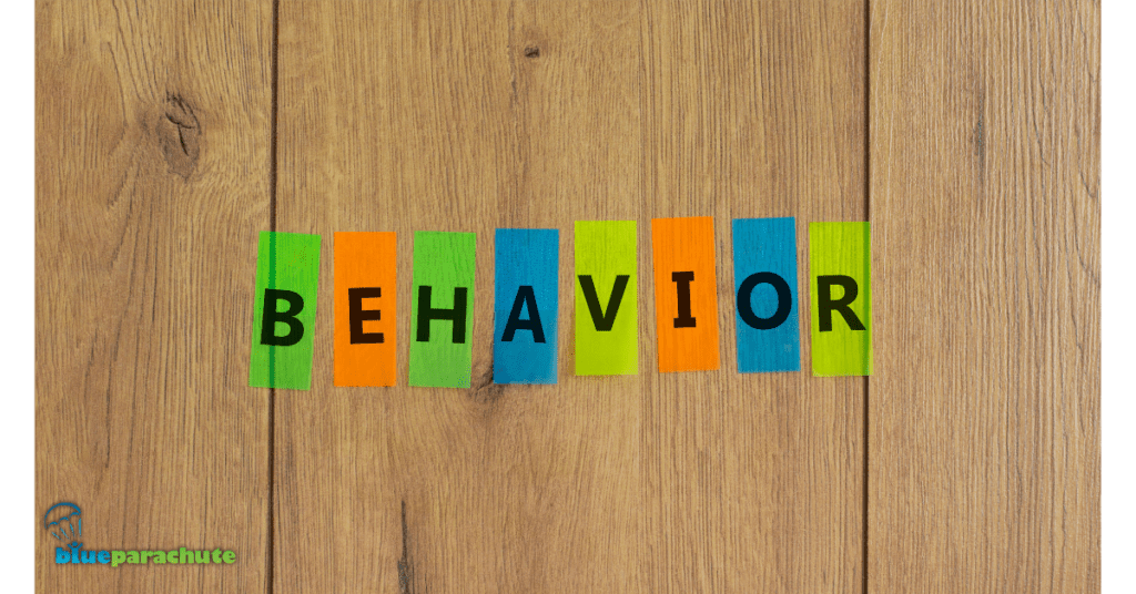 A wood board behind 8 pieces of paper, with each piece having one letter and spelling out the word BEHAVIOR. This piece is about Positive Behavior: Support Plan Examples for Autism.