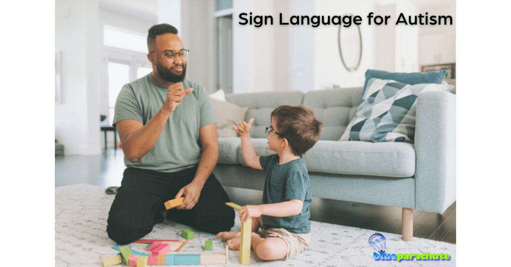 An adult male is sitting on the floor with a male toddler, and the two are communicating with signs. This helps illustrate sign language for autism.