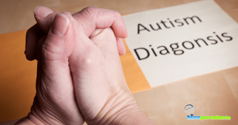 An adult’s hands are on top of a table, clasped together, as if the person could be anxious. On the table is a paper that reads Autism Diagnosis. This indicates that this blog discusses getting an autism diagnosis.